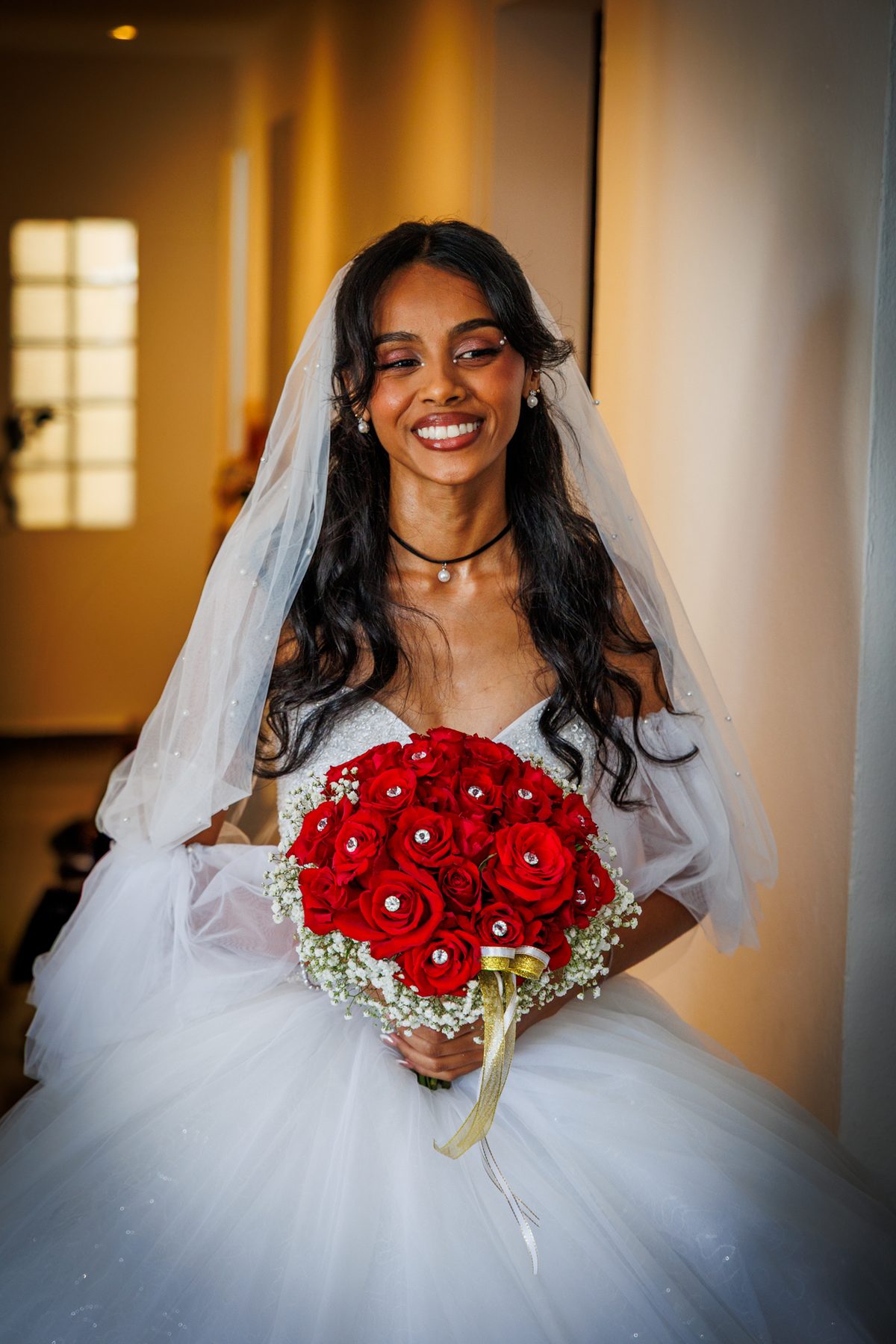 Mariée et son bouquet de roses rouges
